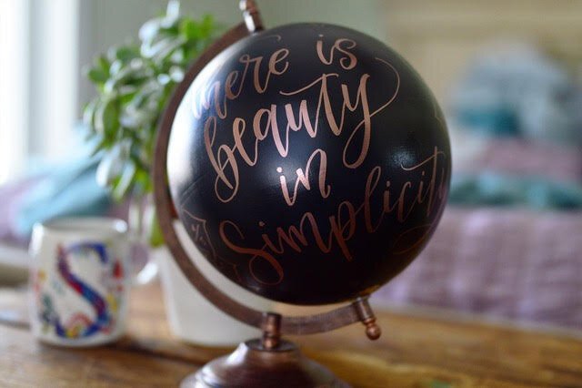 Selena Ashley, a graphic designer and hand-lettering artist, embellishes globes with inspirational sayings.