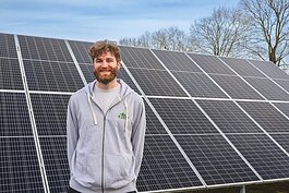 Joe Lange by solar panels at Northside Community Center in Ann Arbor.