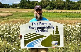 Greg Dunn's Blackbird Farm in Coopersville received MAEAP verification in 2020. Dunn shows off his new sign in one of their produce fields.