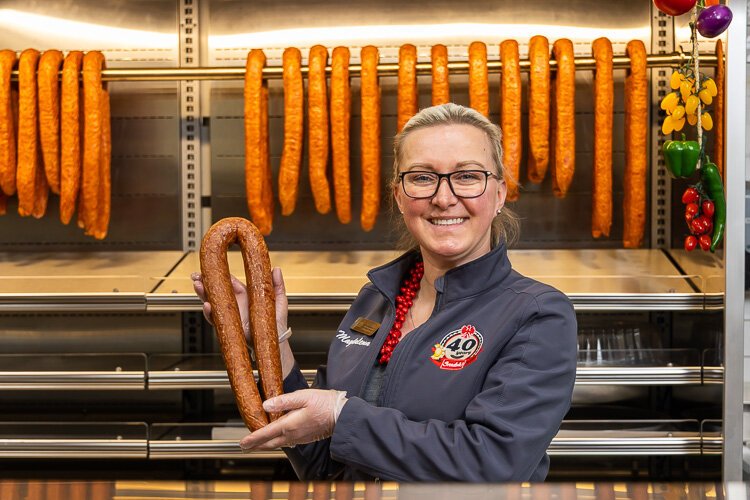 Magdalena Srodek shows off smoked sausage made in-house at her family's Sterling Heights facility.