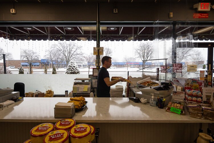 An employee prepares carryout items at Ventimiglia's.