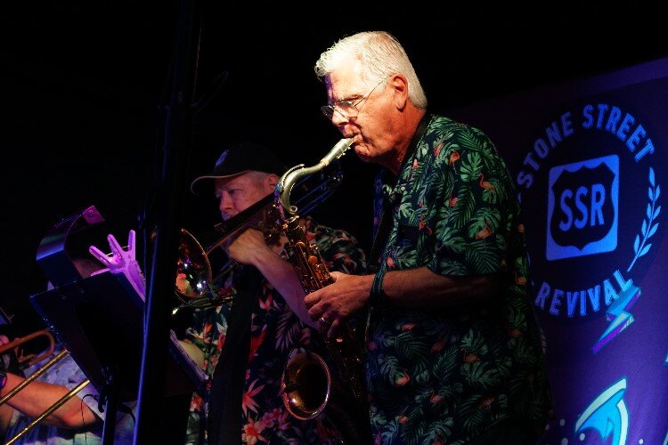 Dan Smith plays saxophone. Alongside him are George Bork on trombone and John Rickert on trumpet.