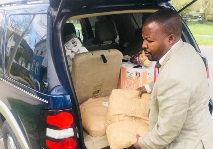 Pastor Joshua Kibezi of the African Community Kalamazoo unloads supplies.