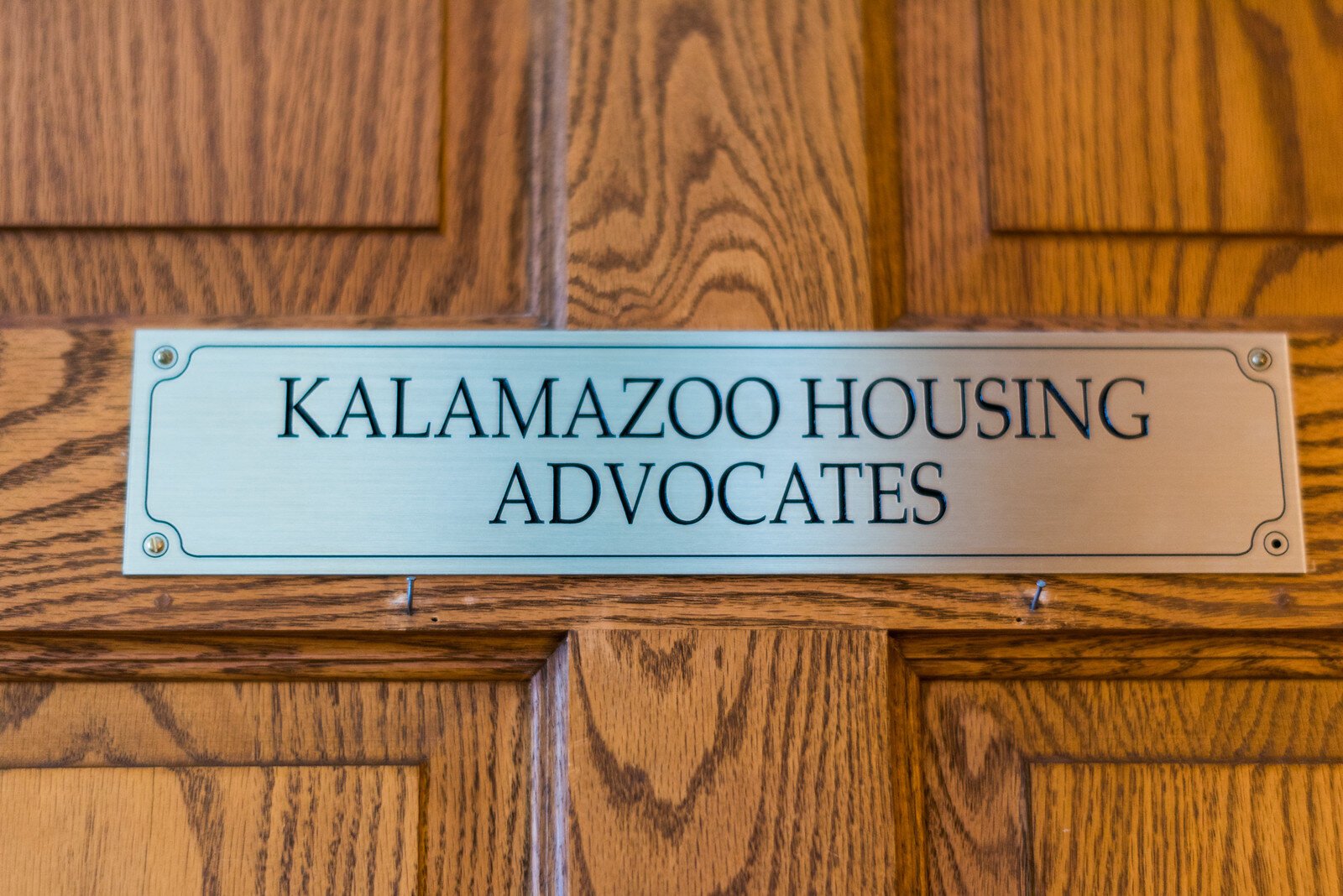 A sign on the door that let's people know they've reached Kalamazoo Housing Advocates.