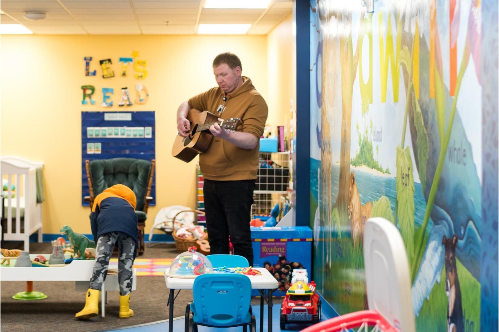 Mike List plays guitar for children.