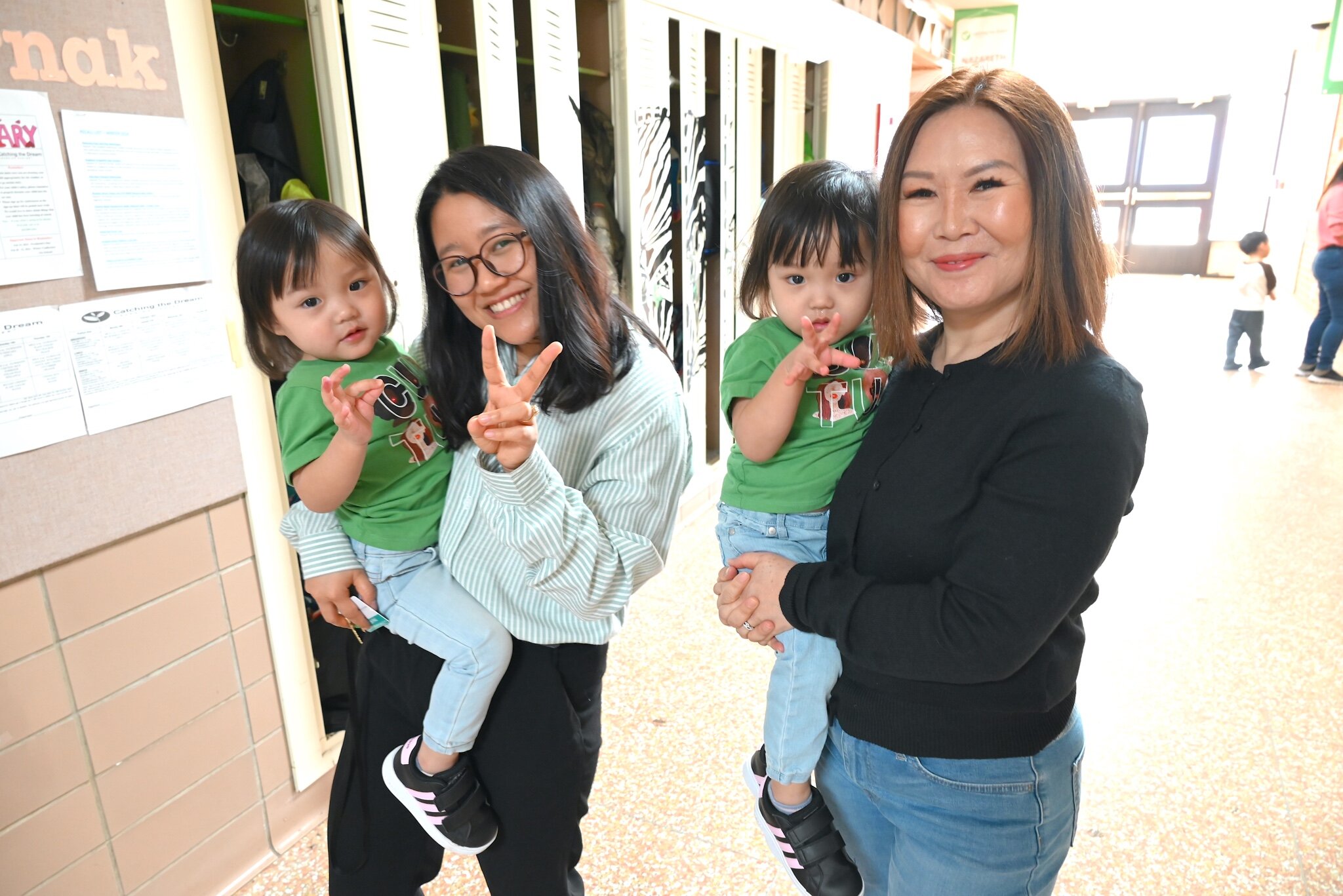 Helen Pau, left, and Lashi Mai hold twin girls at the Burma Center’s Dream Learning Center.
