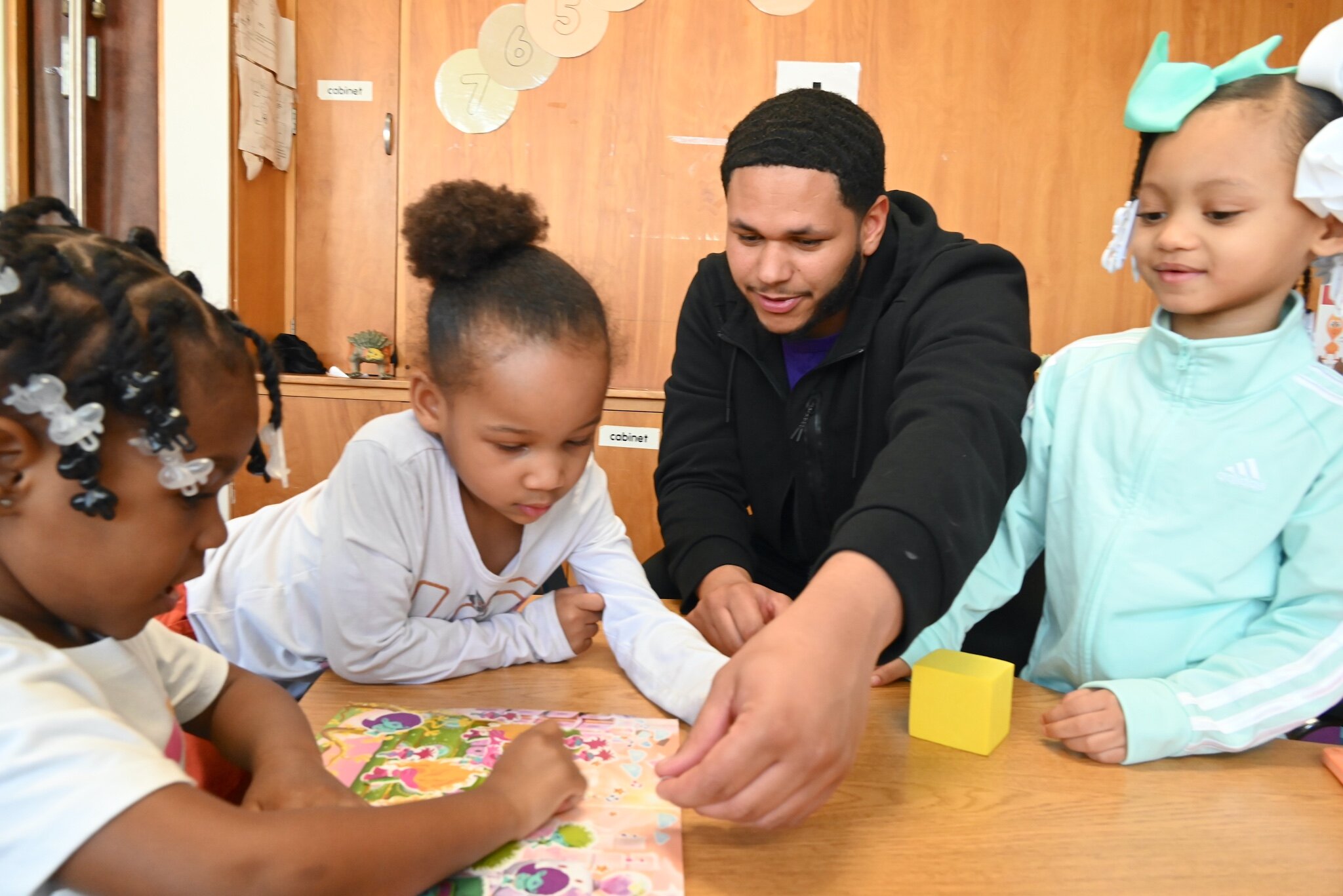 Terrell Jackson works with three young children at New Harvest Christian’s Learning Center.