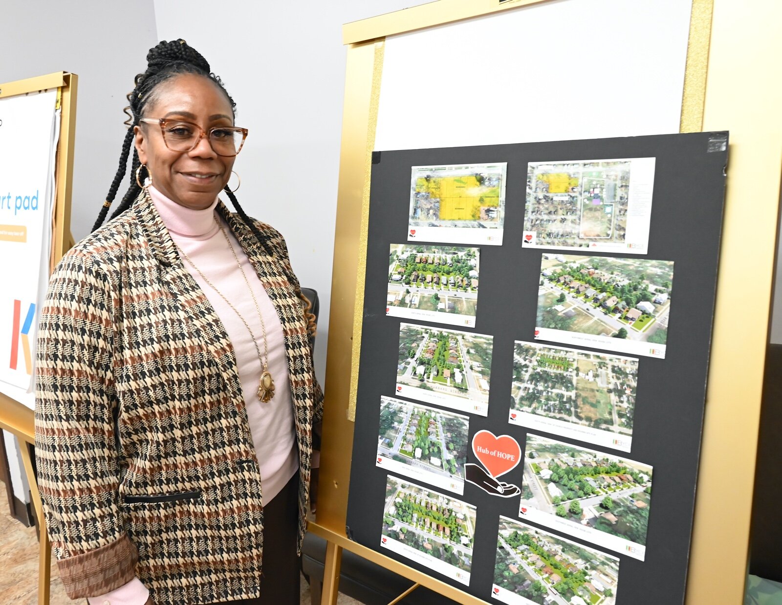 Rev. Monique French, pastor of Washington Heights United Methodist Church, stands next to a poster showing architectural concepts of the planned property development.