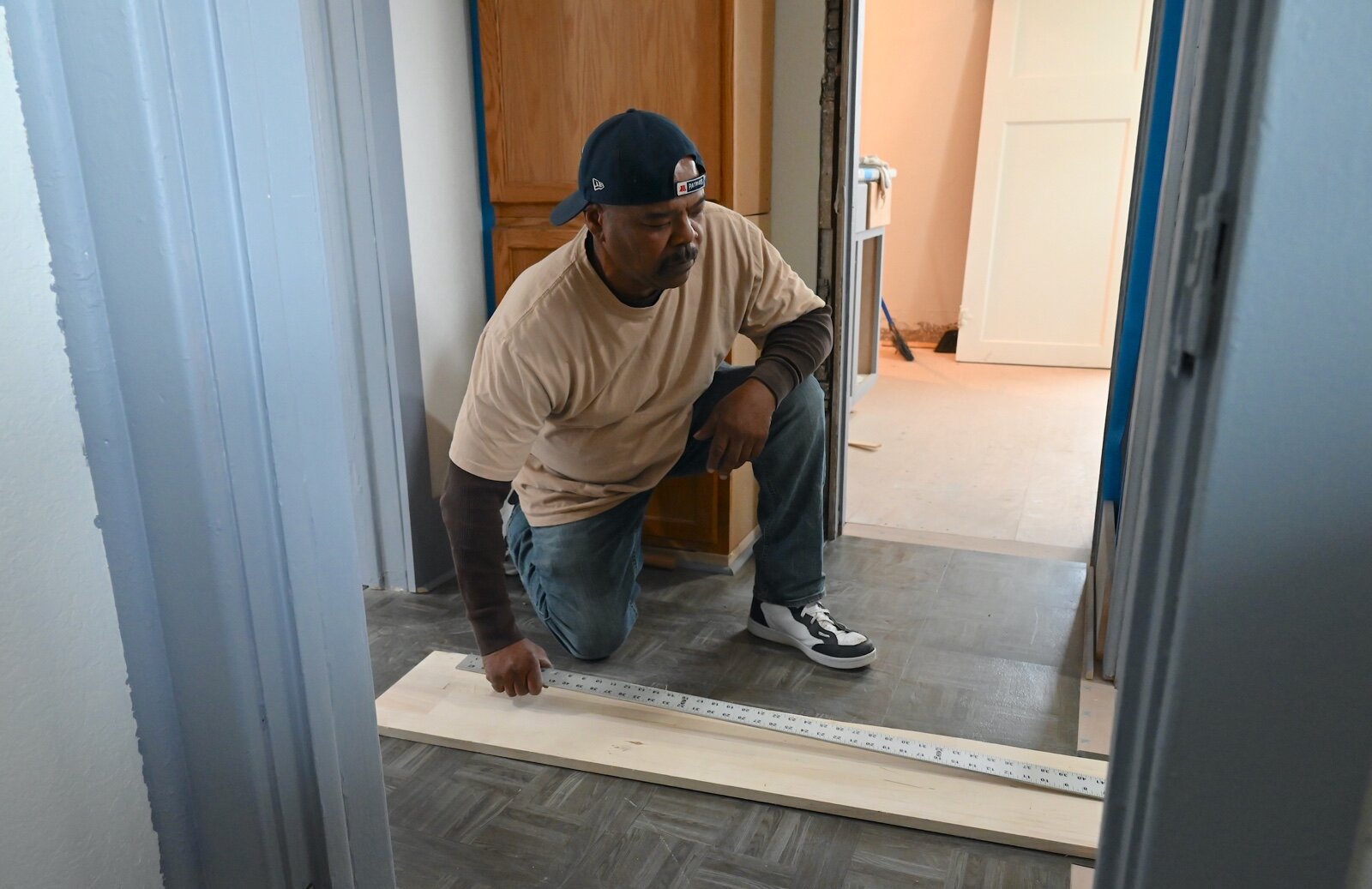 Robert Holley works on the flooring of the house at 238 Greenwood Avenue that Washington Heights United Methodist Church bought and is renovating.