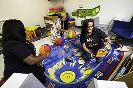 King's Kid Christian Daycare staff members Adrian Robinson, left, Lolita Granger, center and Tamara Jones laugh Wednesday, July 17, 2024, as they play with toys in one of the classrooms in the Detroit child care center.