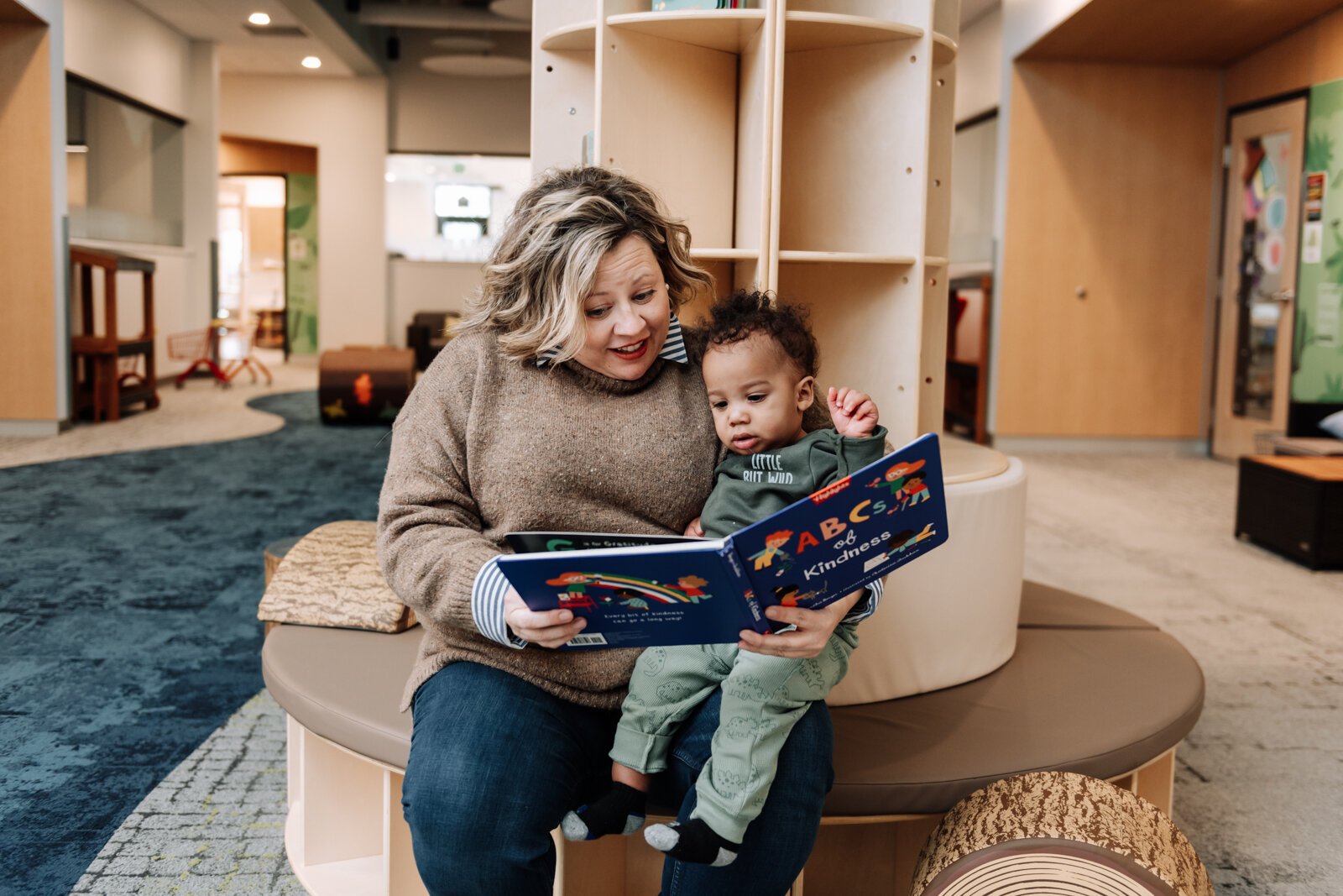 Kelli Packnett, Vice President of Education and Engagement at Bridge of Grace, reads to six-month-year-old Grant. 