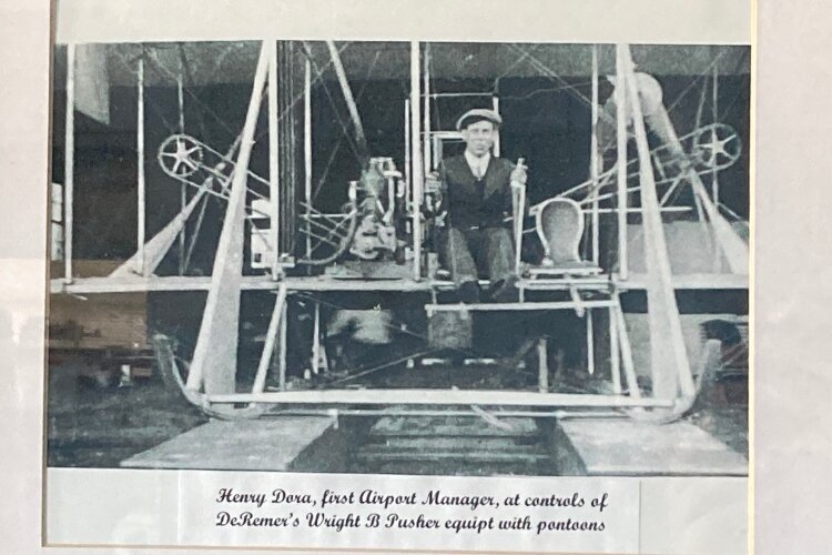 Hanging in the Administration Building is a photo of Henry Dora, the first airport manager, at the controls of DeRemer’s Wright B Pusher.