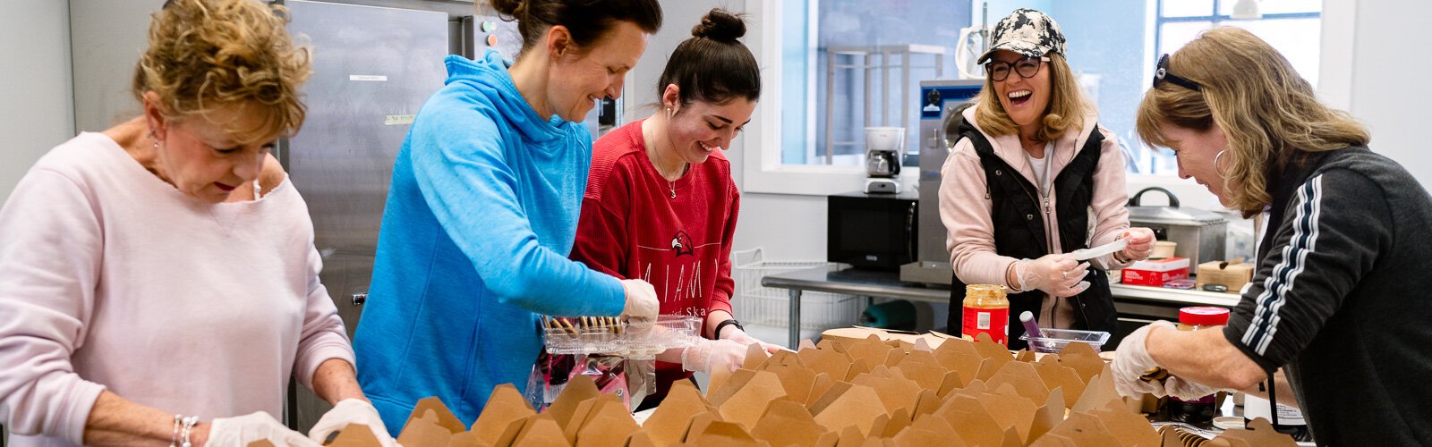 Workers prepare school lunches at Eat More Tea.