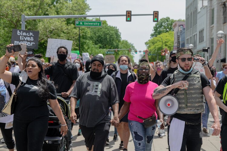 Dan Grady El and Sha'Teina Grady El (center) march hand in hand.