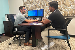 Mark Koepf, vice president and director of government guaranteed lending for University Bank, helps a client at University Bank's new Ypsilanti branch.