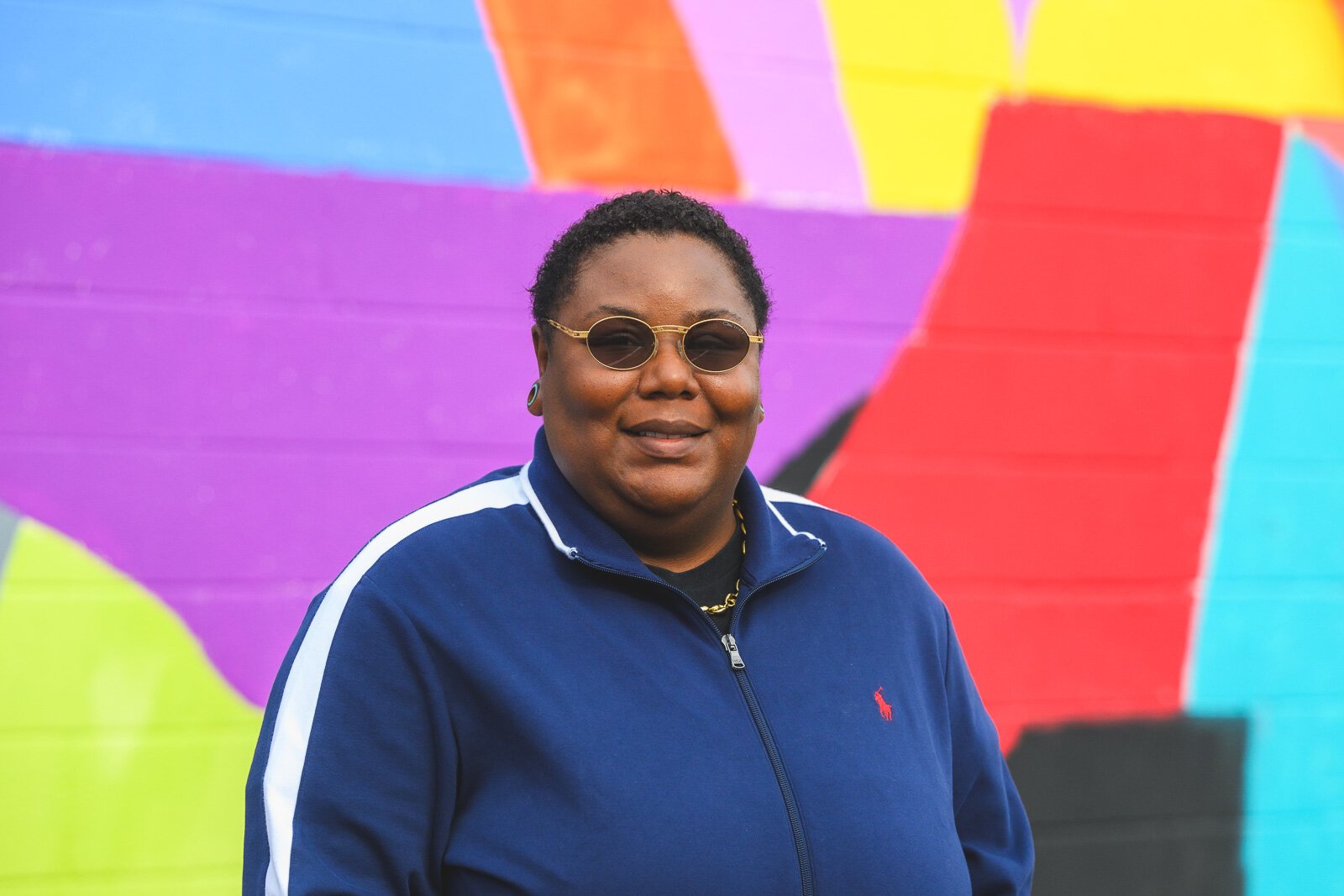 Youth Art Gallery Executive Director T'Onna Clemons in front of the Youth Art Gallery mural at Community Auto Wash.