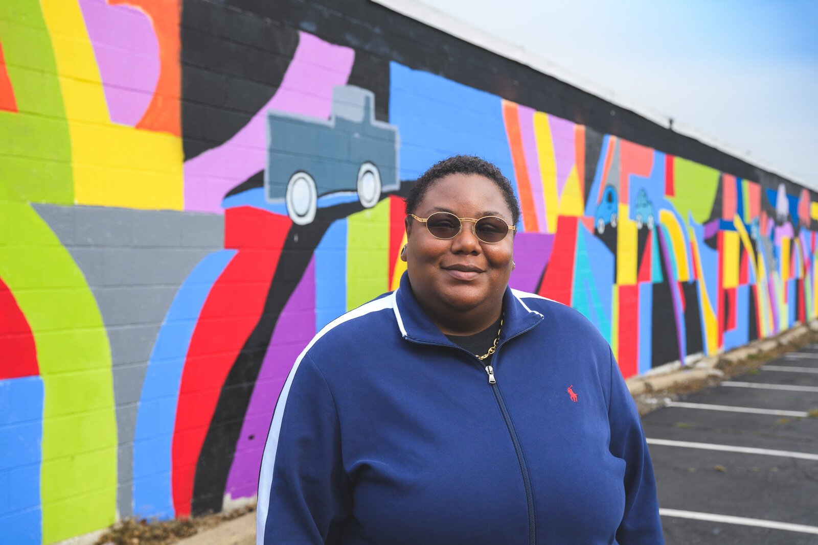 Youth Art Gallery Executive Director T'Onna Clemons in front of the Youth Art Gallery mural at Community Auto Wash.