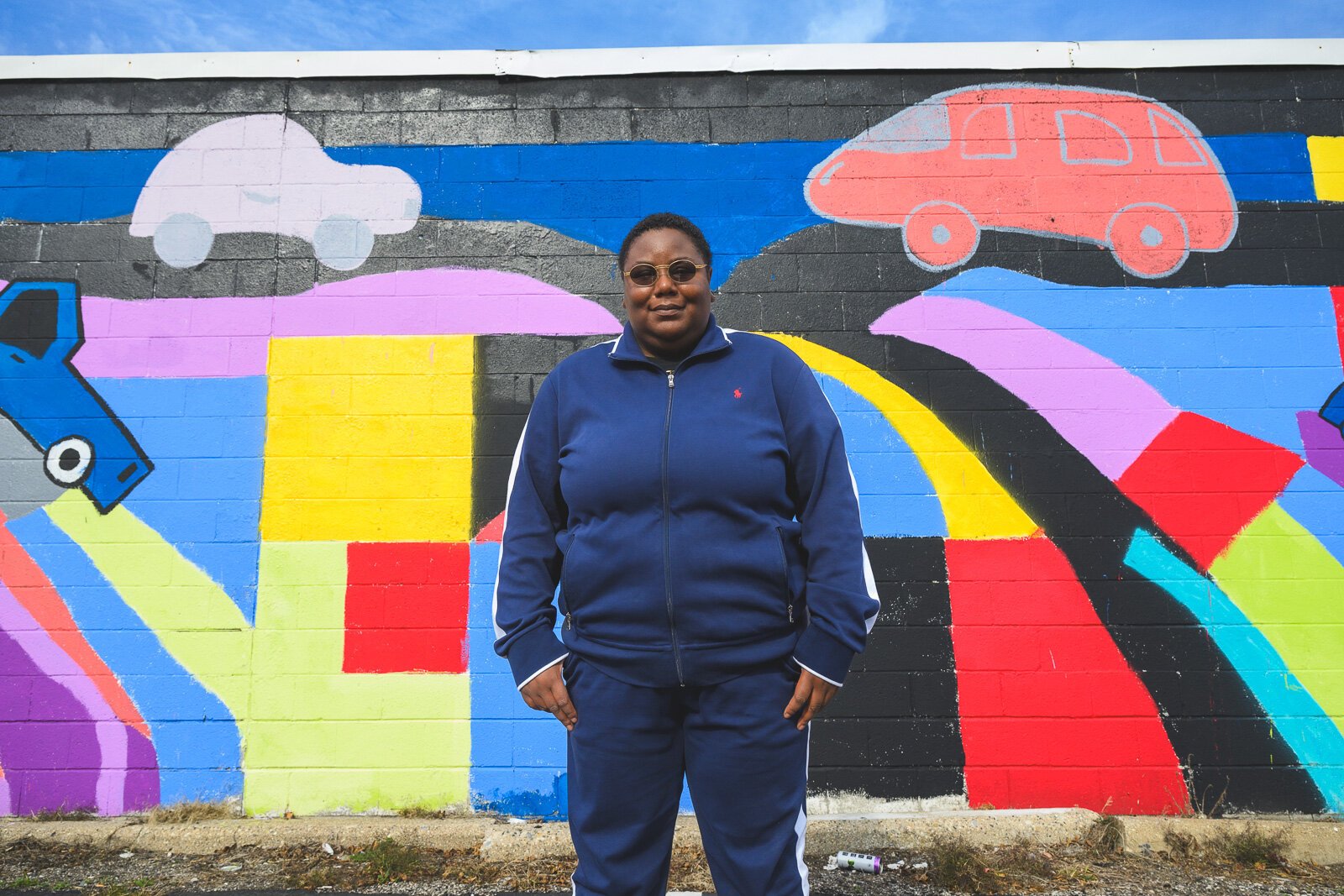 Youth Art Gallery Executive Director T'Onna Clemons in front of the Youth Art Gallery mural at Community Auto Wash.