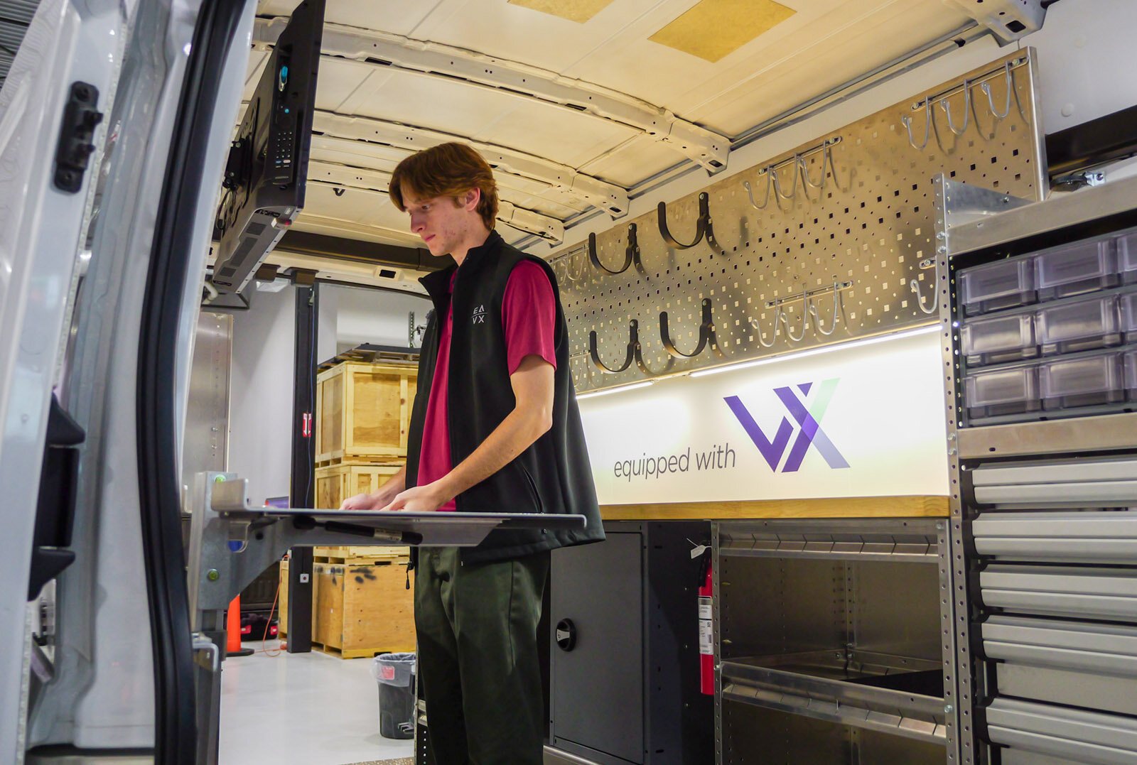 EAVX employee Corbin Fleming-Dittenber demonstrates the versatility and customization of a Ford eTransit upfit with Masterack products and VX technology.