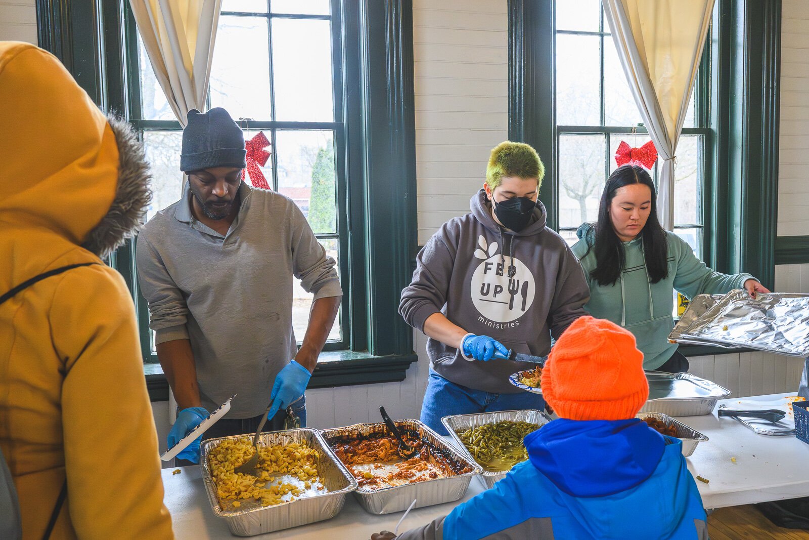 Todd Crowley, Kieren Berres, and Maddy Tong of FedUp Ministries serving food at the Ypsilanti Freighthouse daytime warming center.