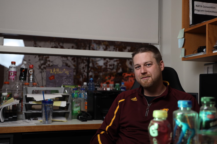 Dr. Kevin Miller surrounded by commercial sports drinks in his office