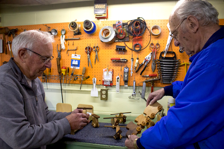 Don Hire, Secretary of the Mid-Michigan Woodcrafters Club, and Tom Delia, President of the Mid-Michigan Woodcrafters Club, inspect some of the toys that have already been made to give to charity at Christmas this year.