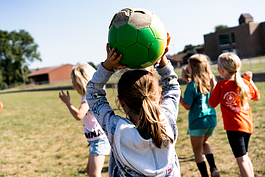 A girl gets ready to throw a soccer ball at PEAK after school program in Mt. Pleasant