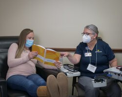 A pregnant patient reviews her vitals with Diane Traenkle, D.O., obstetrician/gynecologist and one of the Centering providers, during her belly check.