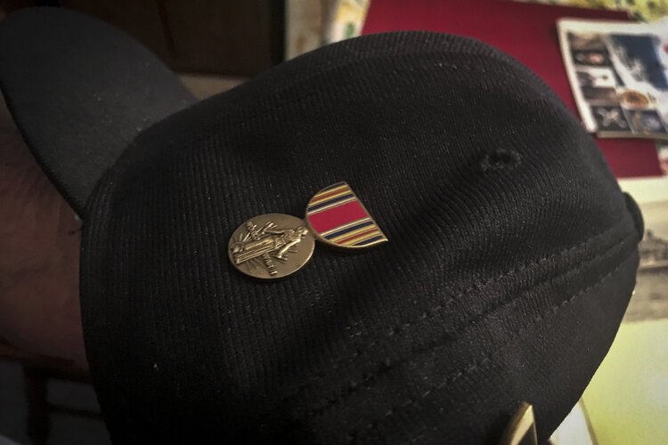 •	Henry Meabrod Sr. shows his WWII victory medal that he has on his hat.