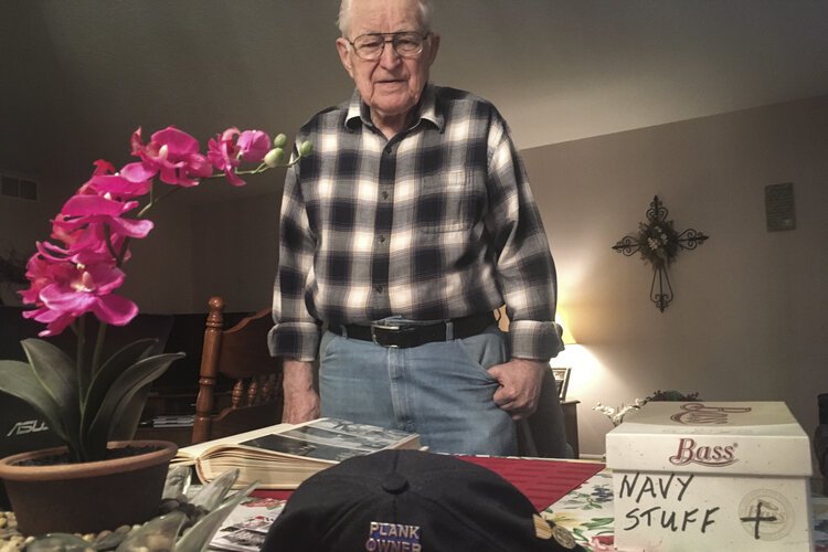 •	Mt. Pleasant resident Henry Meabrod Sr. looks at memorabilia from his time in the Navy during WWII.