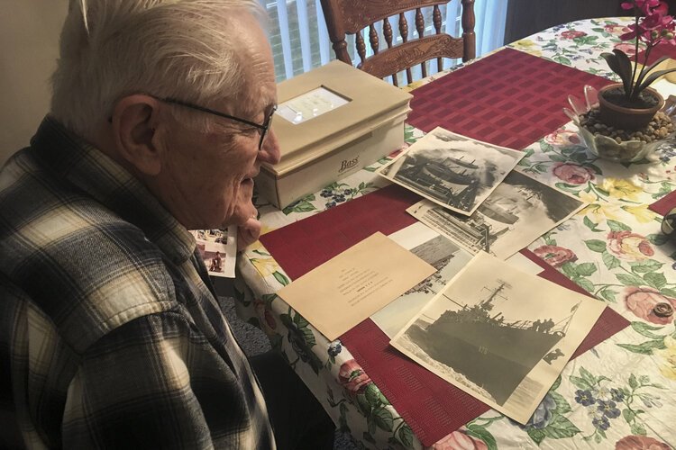 •	Mt. Pleasant resident Henry Meabrod Sr. looks at memorabilia from his time in the Navy during WWII.