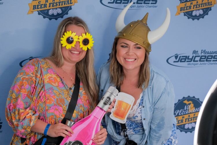 Halaina Laverty (left) and Bo Lacey (right) don props in the photo booth at the Craft Beer Festival in Mt. Pleasant on Saturday, June 8, 2024. Event sponsor In a Snap Photobooths provided the attraction.