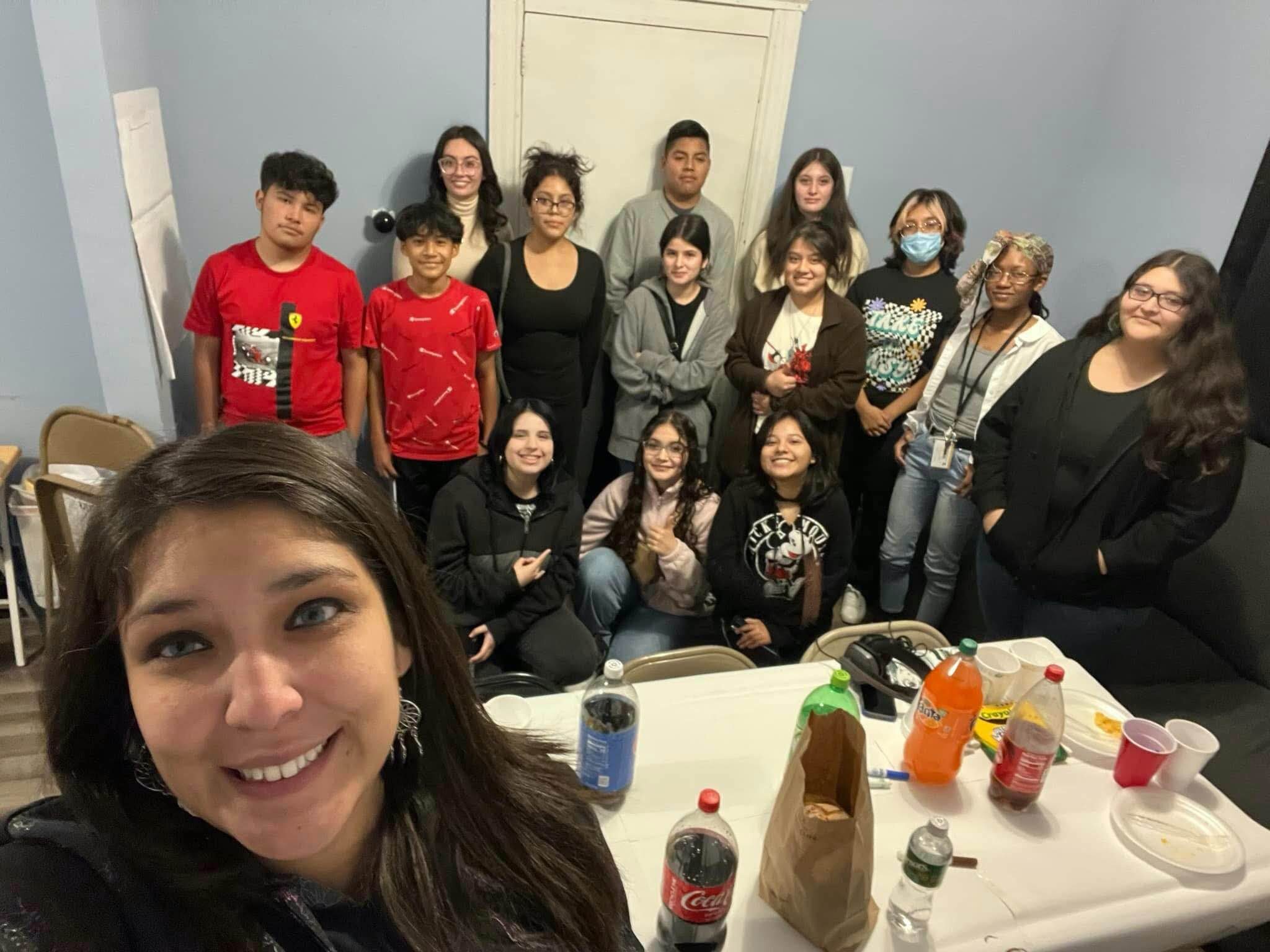 One Michigan Executive Director Samantha Magdaleno, front left, enjoys a “Friendsgiving dinner” with a group of teen participants in One Michigan’s CALM program