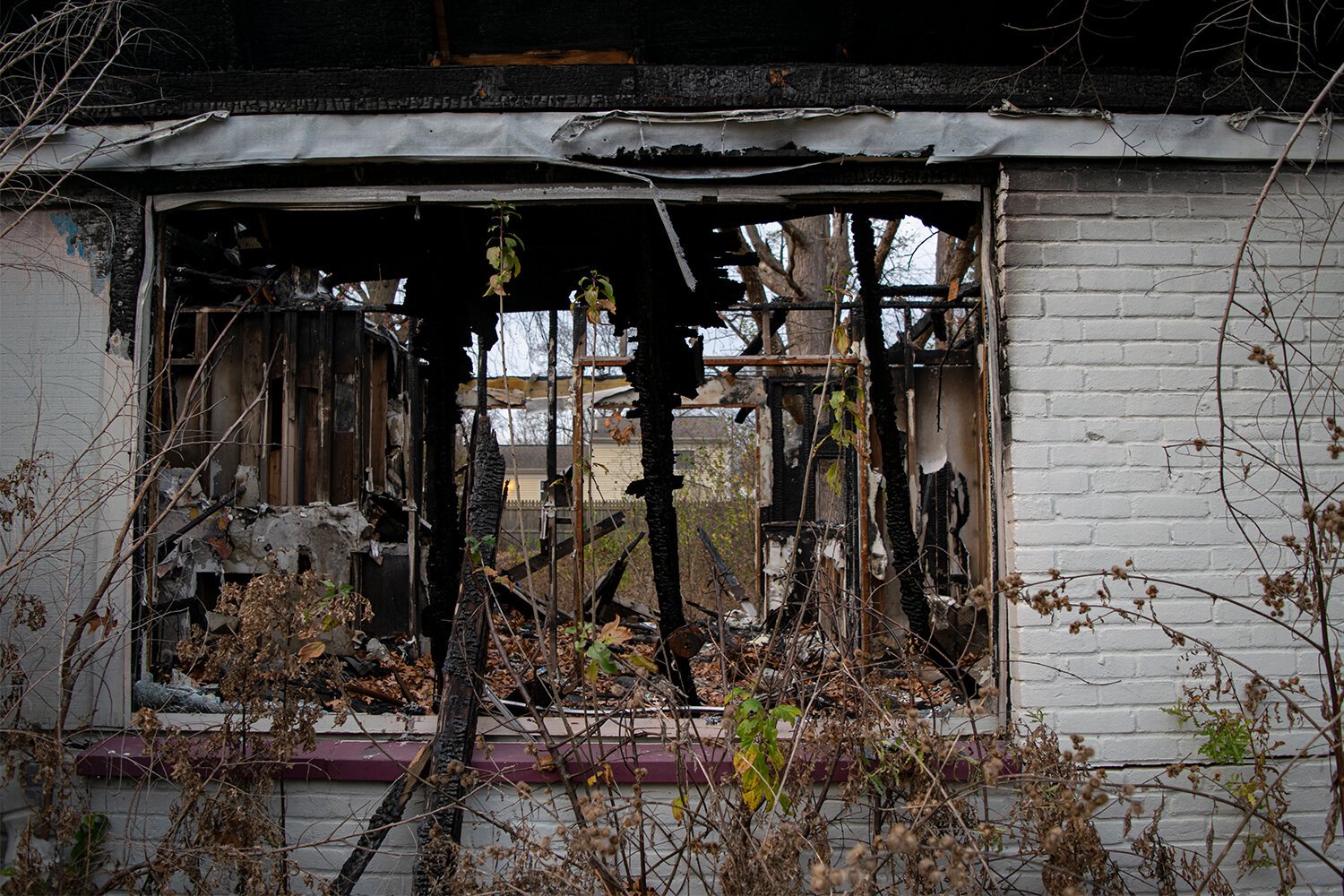 With no roof and barely one wall left standing, one can look through 2114's dining room window from the middle of Home Ave and see into the back yard of the house across the street on Barbara Dr.