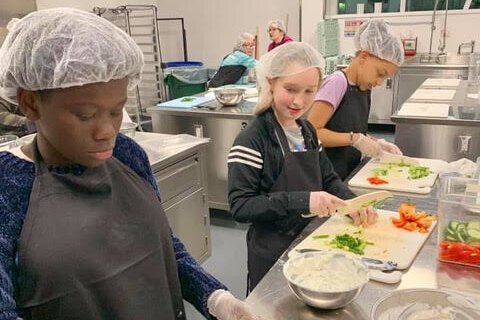 Kids prepare food at The Learning Kitchen.