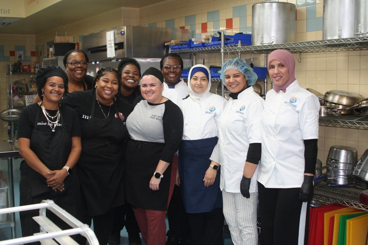 Students and instructor take a break for a photo: (Left to Right) Carmelina Capozzoli, Joy Clark, Charisse Copeland, Lashonta Williams, Chef Kim Marks-Ball, Tracy Cooper, Israa Jawad, Fatima Jabrane, and Asmahan El Orra