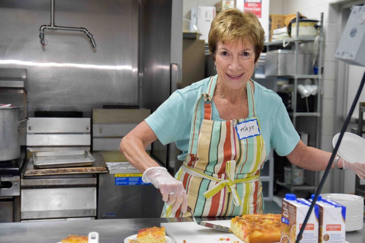 Volunteer Kaye cooking for MCREST guests during her church’s host week