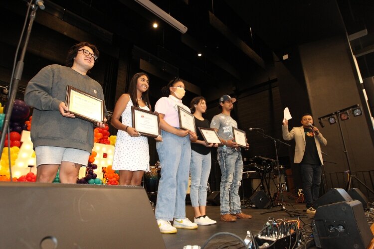 Latin Americans United for Progress Executive Director Johnny Rodriguez, right, acknowledges the recipients of the Community Foundation of the Holland/Zeeland area and LAUP scholarships during the LAUP ¡Fiesta! at the Holland Civic Center on July 9.