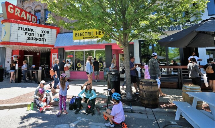 Visitor activity in downtown Grand Haven spills into areas formerly reserved for vehicles.