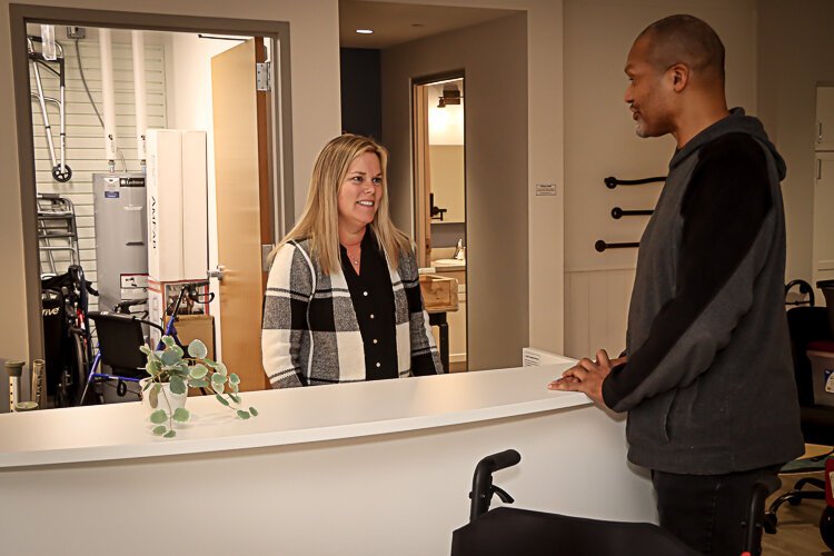 Ronny Richardson and Renee Thompson talk across the counter at the Occupational Therapy Equipment Loan Closet.