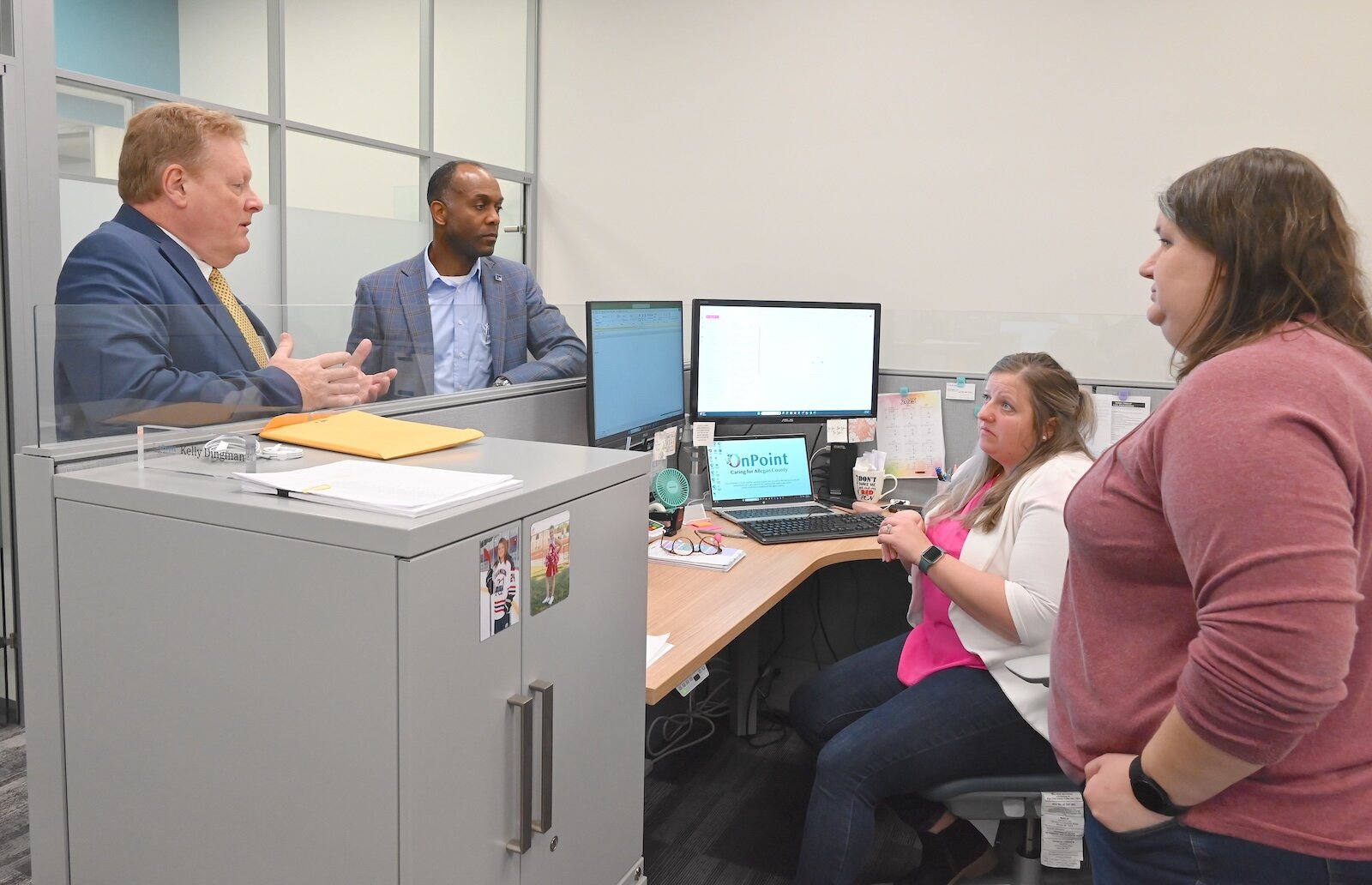 Mark Witte chats with OnPoint staff: from left,  Andre Pierre, Jr., chief administrative officer; Kelly Dingman, accounting supervisor, and Sarah Lumbert, general accountant.