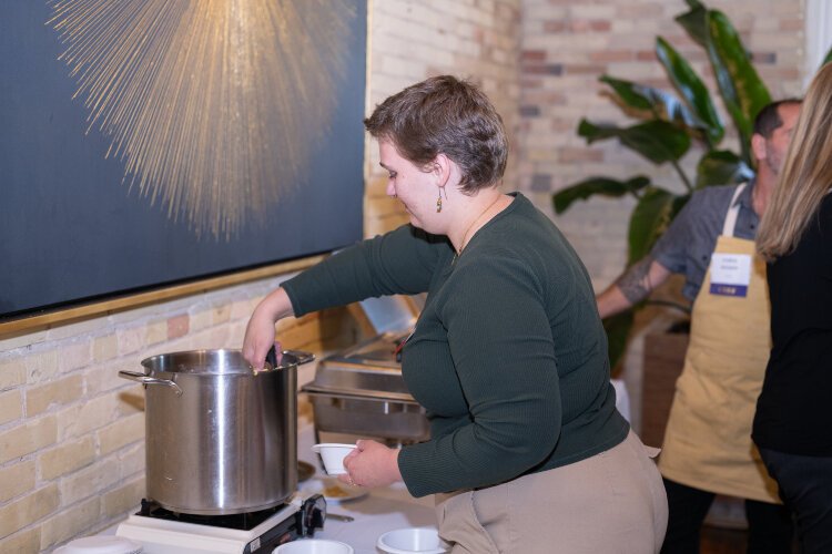 A MOWWM volunteer assists a local chef in serving his winning recipe at MOWWM's Chef's Specialty fundraiser.