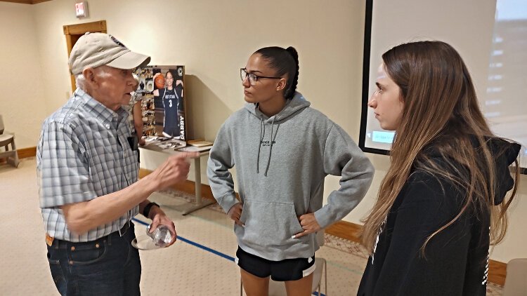 West Ottawa basketball players Taylor Catton, right, and Gabby Reynolds speak to a man following a Q&A session at Evergreen Commons.