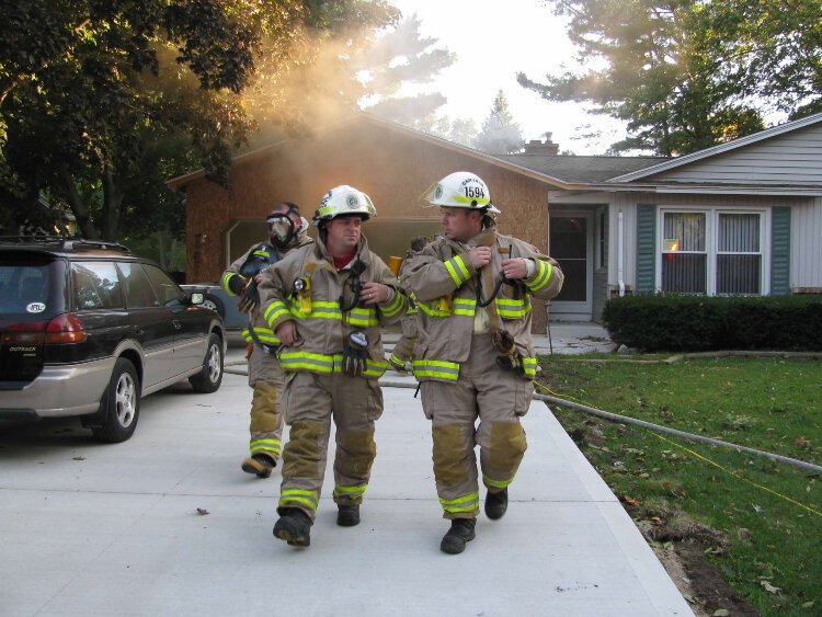 Scott Heerema (left) walks away from a house fire in Park Township. 