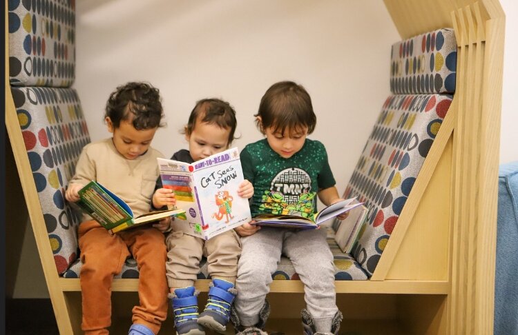 Young children read books at Herrick District Library.