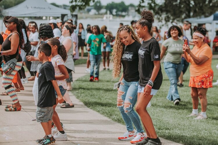 Lauren Beck, center, dances with students at I AM Academy's Juneteenth Freedom Festival.