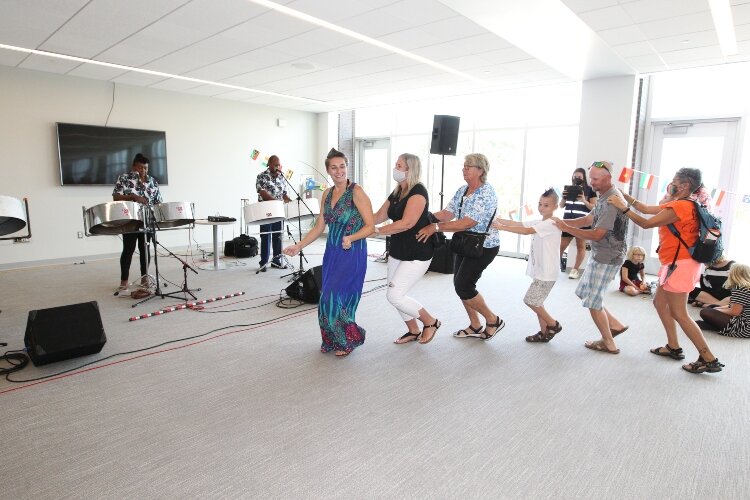 Members of the Holland community conga line dance to The Gratitude Steel Band's version of Buster Poindexter's 1987 single "Hot Hot Hot" in the Children's Fiesta section of the International Festival of Holland at the Holland Civic Center, August 21,