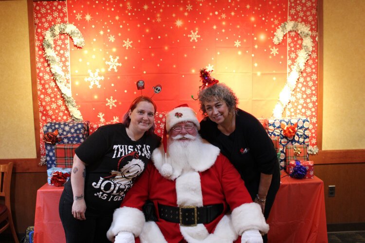 LeighAnne Henderson and CACC Executive Director Lisa Evans pose with Santa.