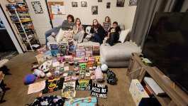 The Henderson family pose with gifts before they are wrapped for the Community Action of Allegan Holiday Giving program.