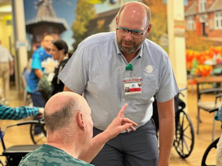 Phil McPherson, director of program integrity at LifeCircles PACE, talks with a client.